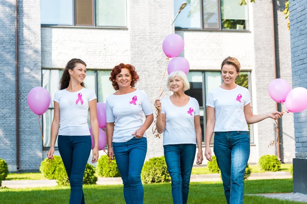 χαμογελώντας γυναίκες κρατώντας ροζ μπαλόνια και το περπάτημα μαζί, έννοια συνειδητοποίηση καρκίνου του μαστού  - Φωτογραφία, εικόνα