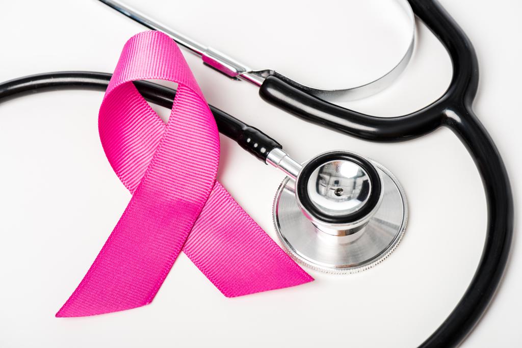 κάτοψη του ροζ μαστού Καρκίνος κορδέλα ευαισθητοποίησης και στηθοσκόπιο απομονωθεί σε λευκό   - Φωτογραφία, εικόνα