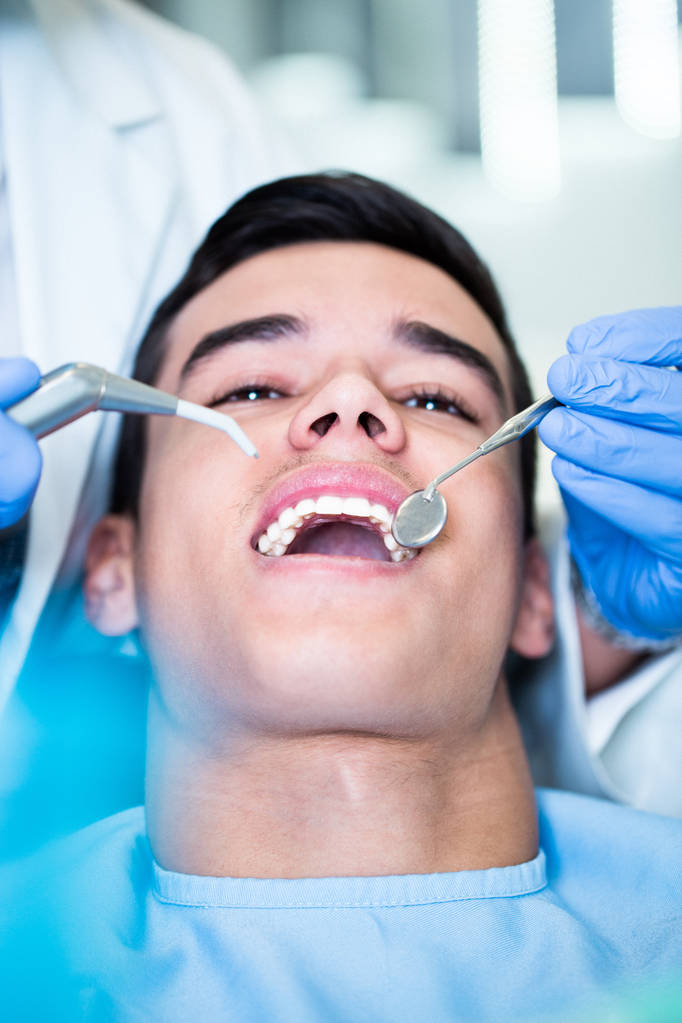 Junger attraktiver Mann erhält eine Zahnbehandlung. Nahaufnahme. - Foto, Bild