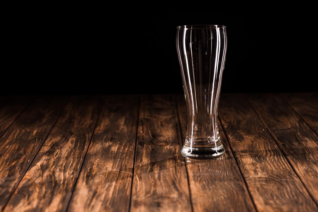 пустая кружка пива за деревянным столом на черном фоне, минималистичная концепция
  - Фото, изображение