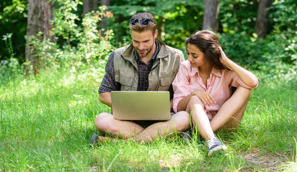 Man and girl looking at laptop screen. Closer to nature. Modern technologies give opportunity to be online and work in any environment conditions. Couple youth spend leisure outdoors with laptop - Photo, Image