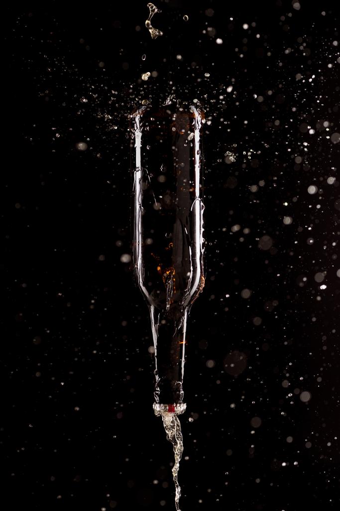 piwo z plamami i butelka nogami wchodzących na białym na czarnym tle - Zdjęcie, obraz