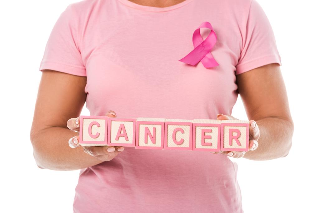 recortado tiro de mujer con cinta rosa celebración de bloques con palabra cáncer aislado en blanco
 - Foto, Imagen