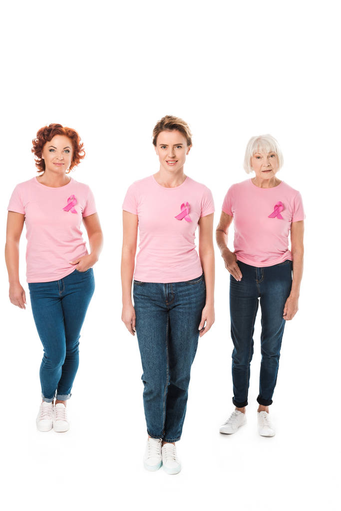 ženy v růžová trička s prsu rakovina povědomí stuhy při pohledu na fotoaparát izolované na bílém  - Fotografie, Obrázek