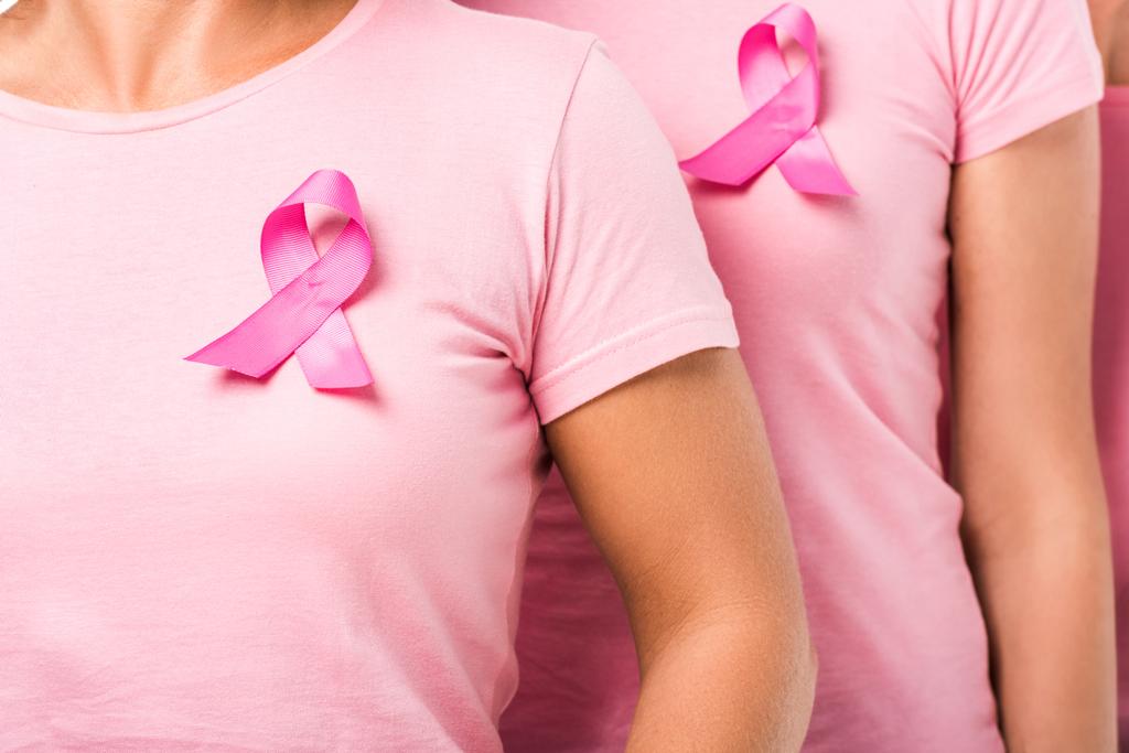 Colpo ritagliato di donne in t-shirt rosa con nastri di consapevolezza del cancro al seno
 - Foto, immagini
