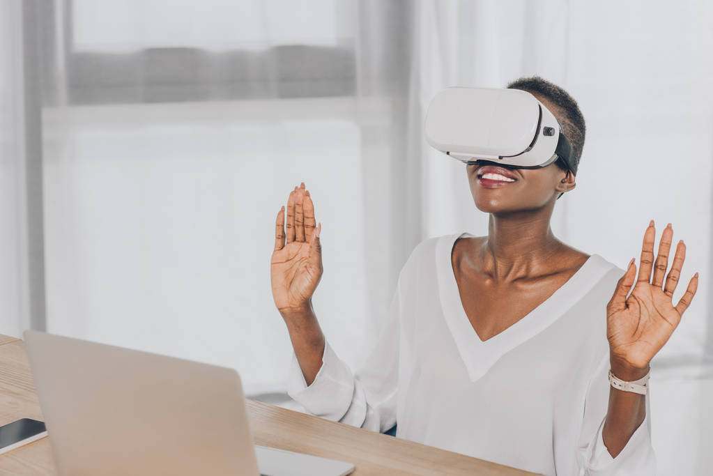 élégant surpris afro-américaine femme d'affaires regardant vers le haut dans le casque de réalité virtuelle au bureau
 - Photo, image