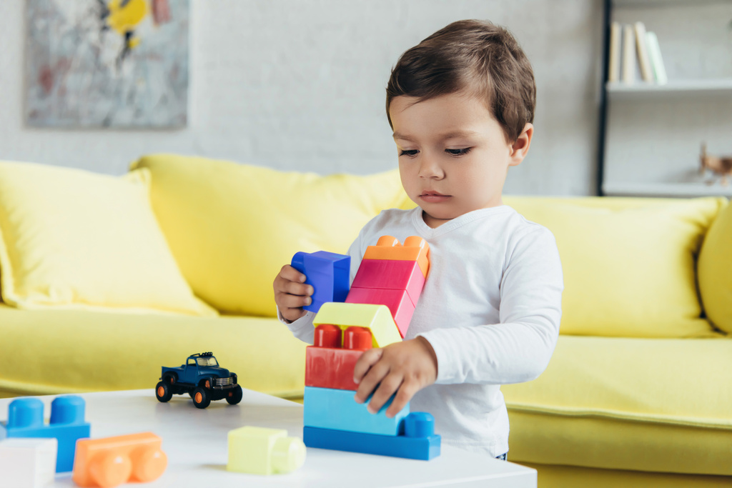 カラフルなコンス トラクター ブロックと自宅のおもちゃの車で遊ぶ少年 - 写真・画像