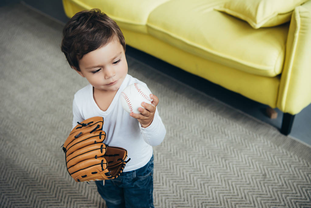 adorabile bambino che gioca con guanto da baseball e palla a casa
 - Foto, immagini