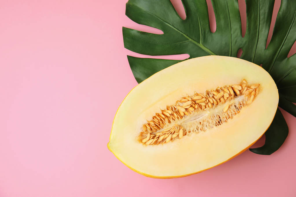 flache Liegekomposition mit Melone, tropischem Blatt und Platz für Text auf farbigem Hintergrund - Foto, Bild