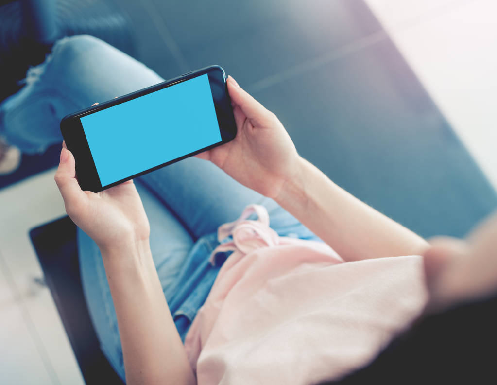 Mujer usando smartphone mientras está sentada en un café
 - Foto, imagen