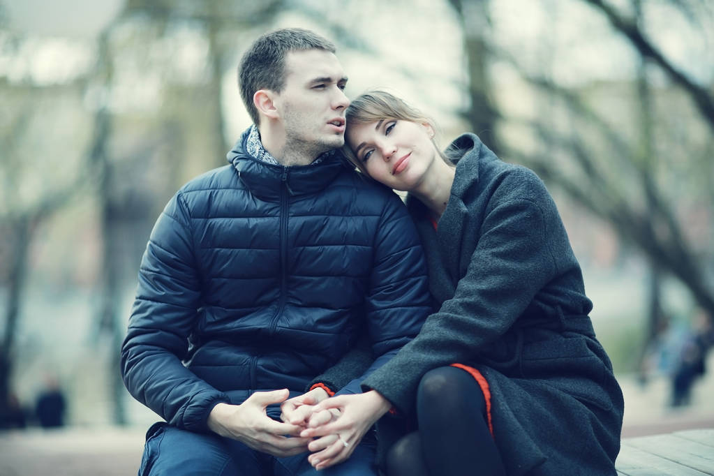 Genç erkek ve kadın kış Park, romantik mutlu çift birlikte bankta oturan - Fotoğraf, Görsel
