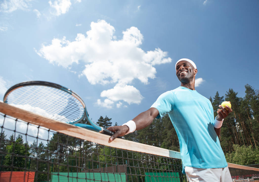 陽気な男は屋外でテニスの試合を楽しんでいます。 - 写真・画像