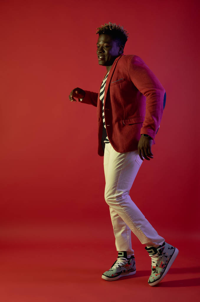 fröhlicher Mann tanzt auf rotem Hintergrund - Foto, Bild
