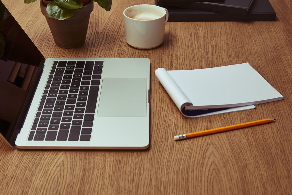 laptop, kávé, jegyzetfüzet és ceruza-a fából készült asztallap - Fotó, kép