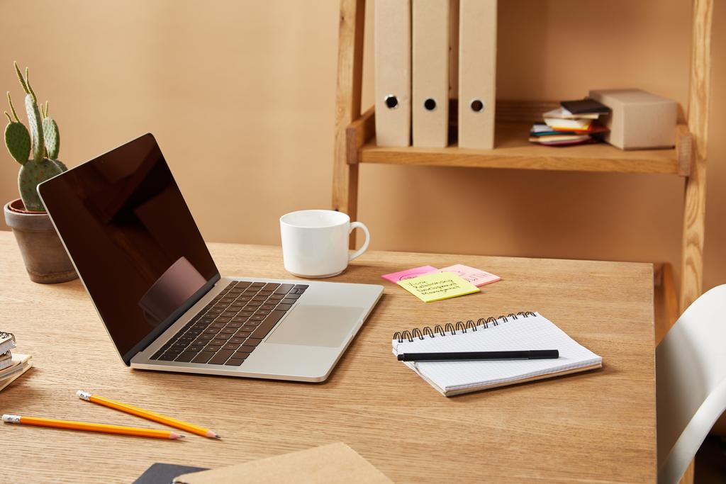 laptop, τετράδια και μολύβια στο ξύλινο τραπέζι στο σπίτι - Φωτογραφία, εικόνα