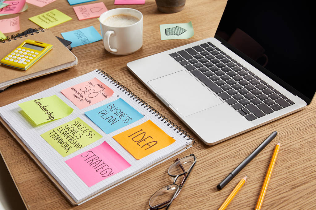 adesivos de papel com estratégia de negócios, óculos e laptop na mesa
 - Foto, Imagem