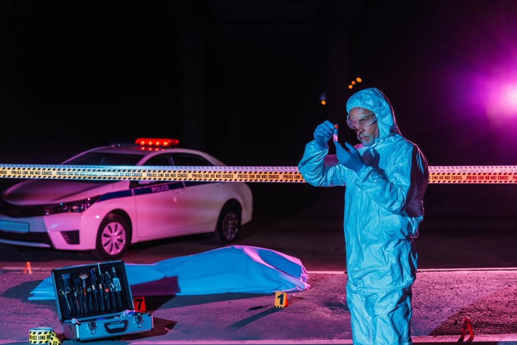 koruyucu elbise ve lateks eldiven ceset ile olay yerinde delil toplama orta yaşlı erkek kriminoloji uzmanı  - Fotoğraf, Görsel