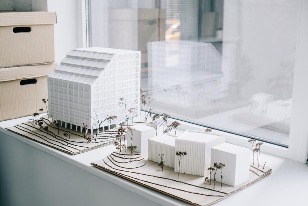 modelos de arquitectura blanca en el alféizar de la ventana en la oficina moderna luz
 - Foto, imagen