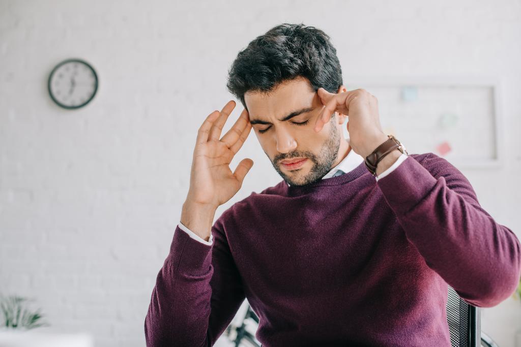 empresário cansado em camisola borgonha com dor de cabeça no escritório
  - Foto, Imagem