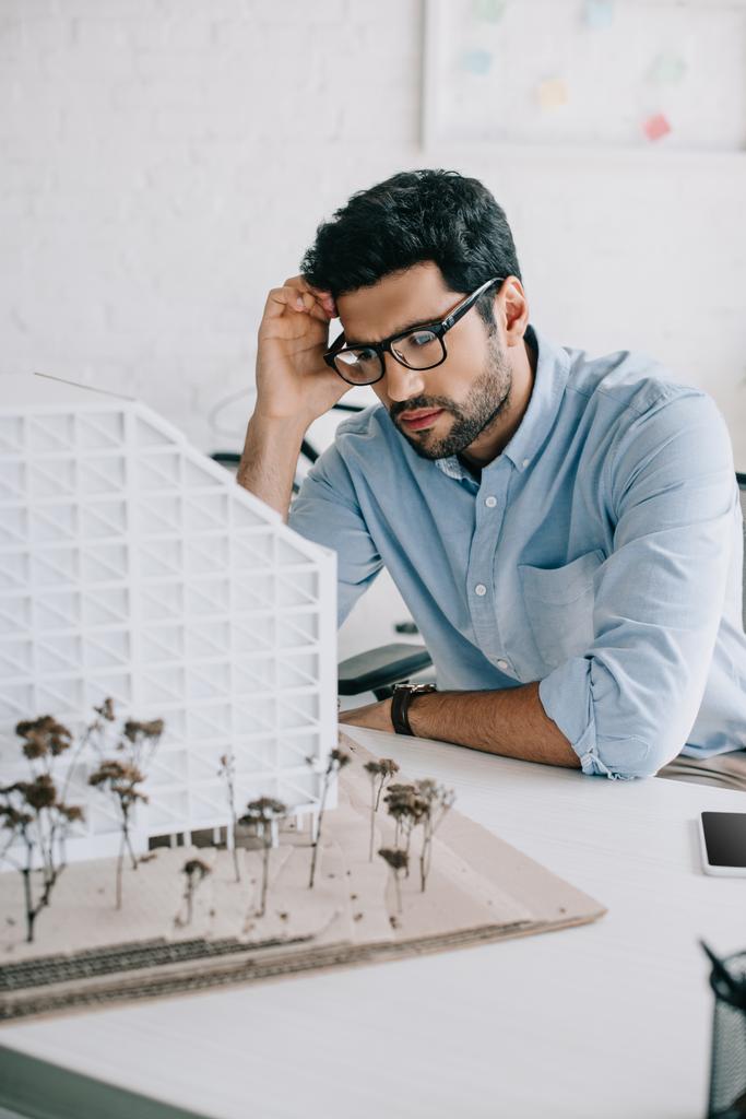 upset architect looking at architecture model in office - Photo, Image