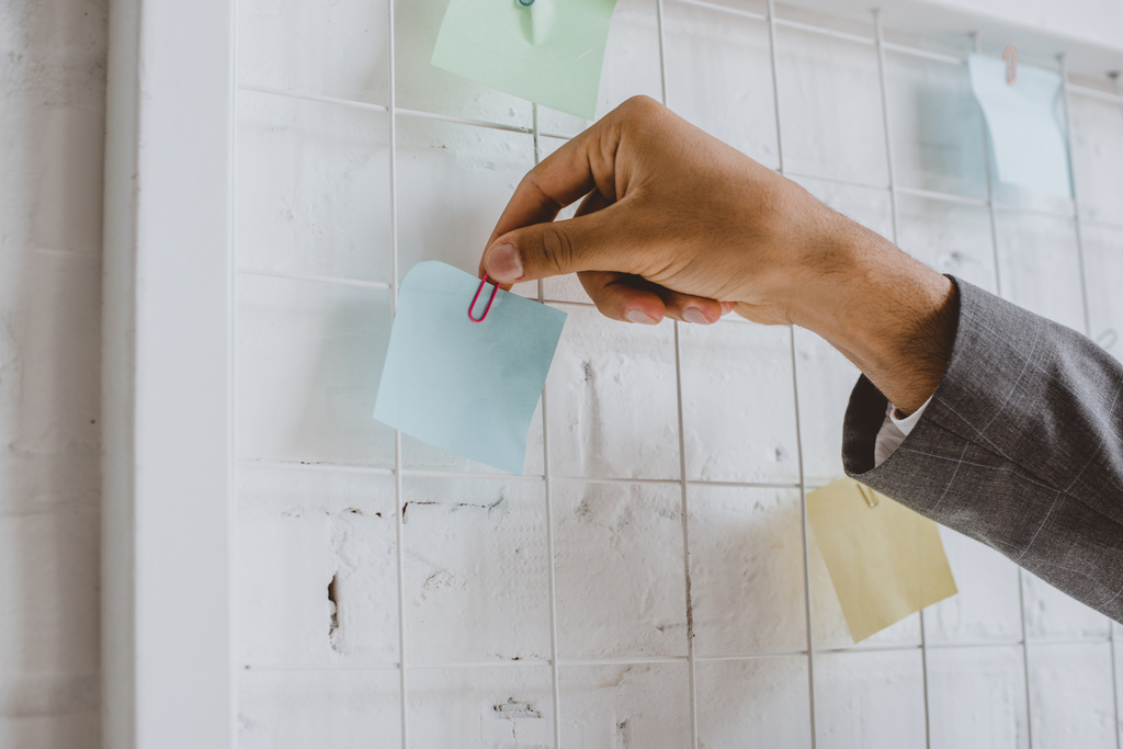 cropped image of businessman taking paper sticker from task board in office - Photo, Image
