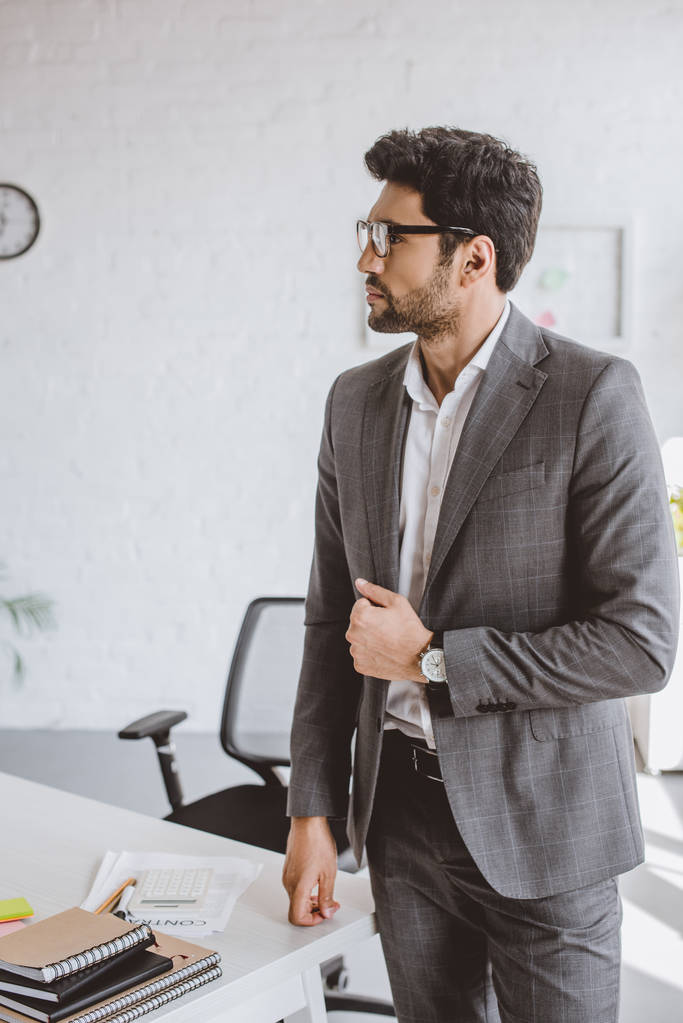 handsome businessman standing and looking away in office - Photo, Image
