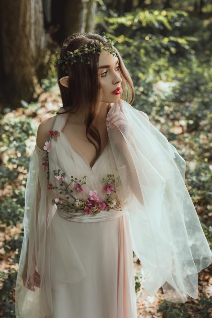 mystinen tonttu tyylikäs mekko kukkia metsässä
 - Valokuva, kuva