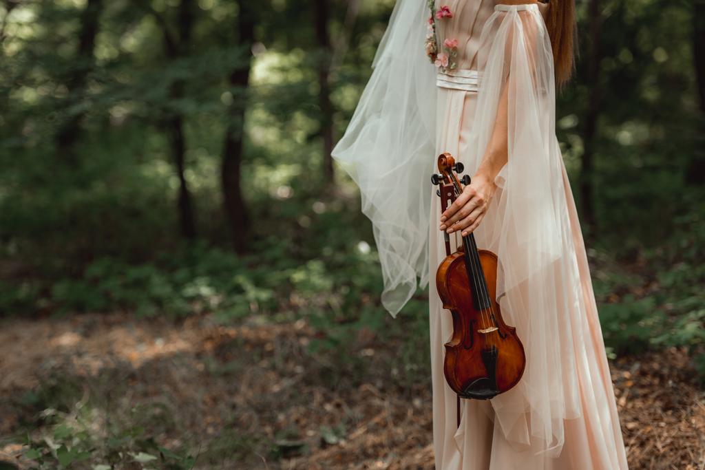 rajattu näkymä tyttö mekko kukkia tilalla viulu metsässä
 - Valokuva, kuva