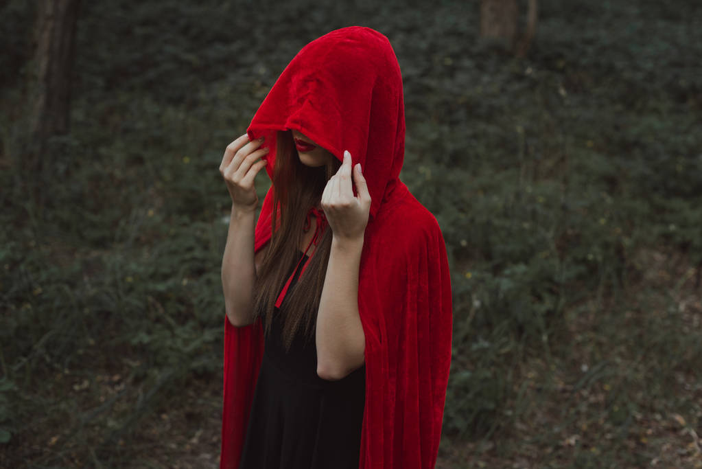 mystic girl in red cloak and hood in forest - Photo, Image