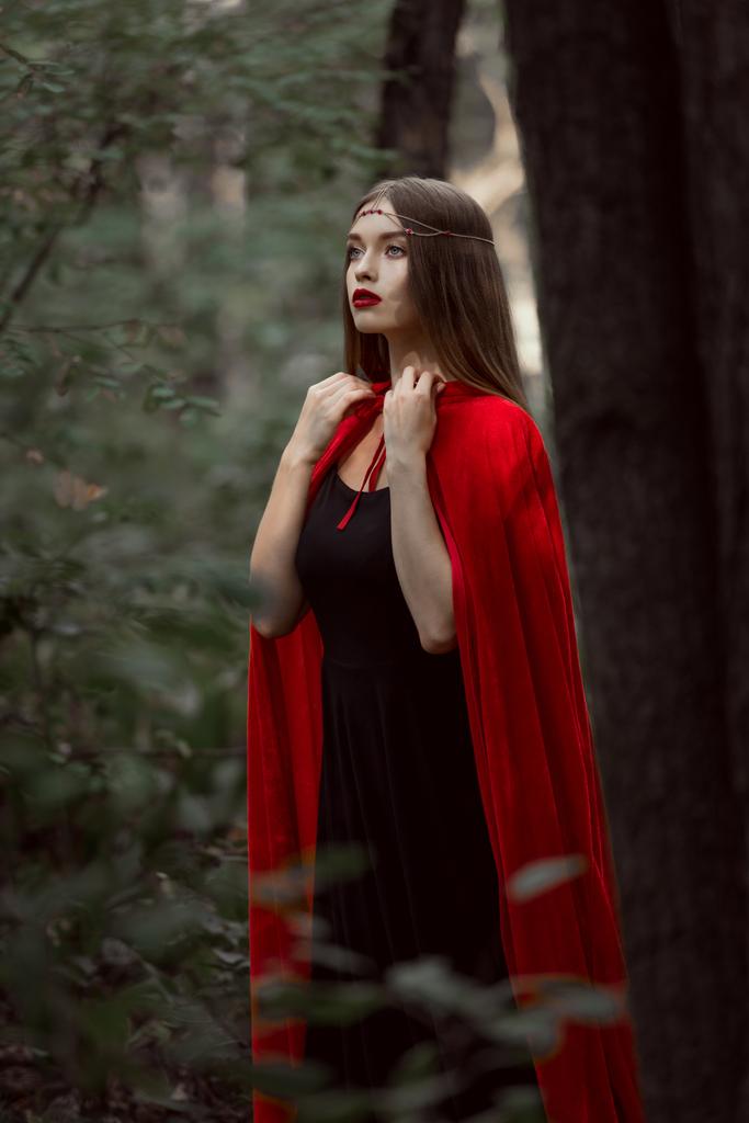 elegantes mystisches Mädchen in rotem Mantel im Wald - Foto, Bild