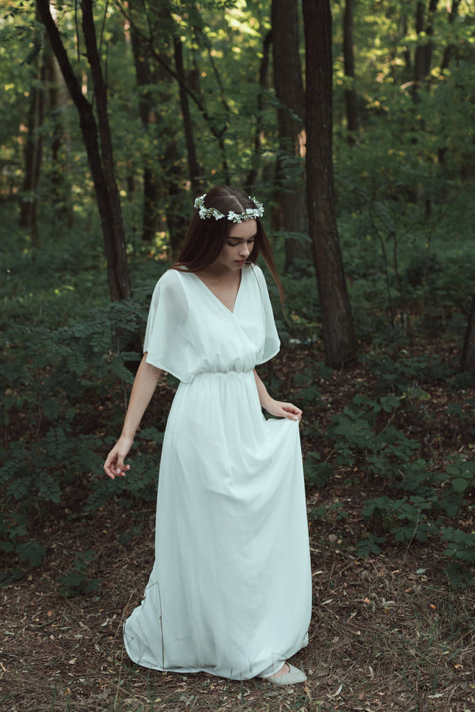 beautiful tender girl in white dress walking in forest - Photo, Image