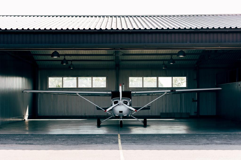маленький современный белый самолет, стоящий в ангаре
  - Фото, изображение