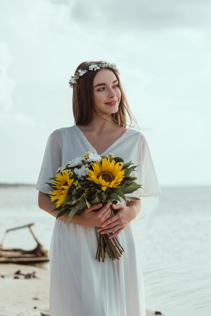 elegantní usměvavá dívka držení kytice slunečnice u moře  - Fotografie, Obrázek