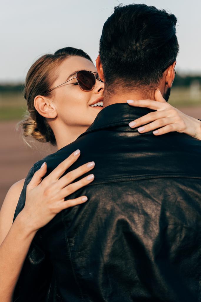 sorrindo mulher atraente abraçando namorado em jaqueta de couro
  - Foto, Imagem