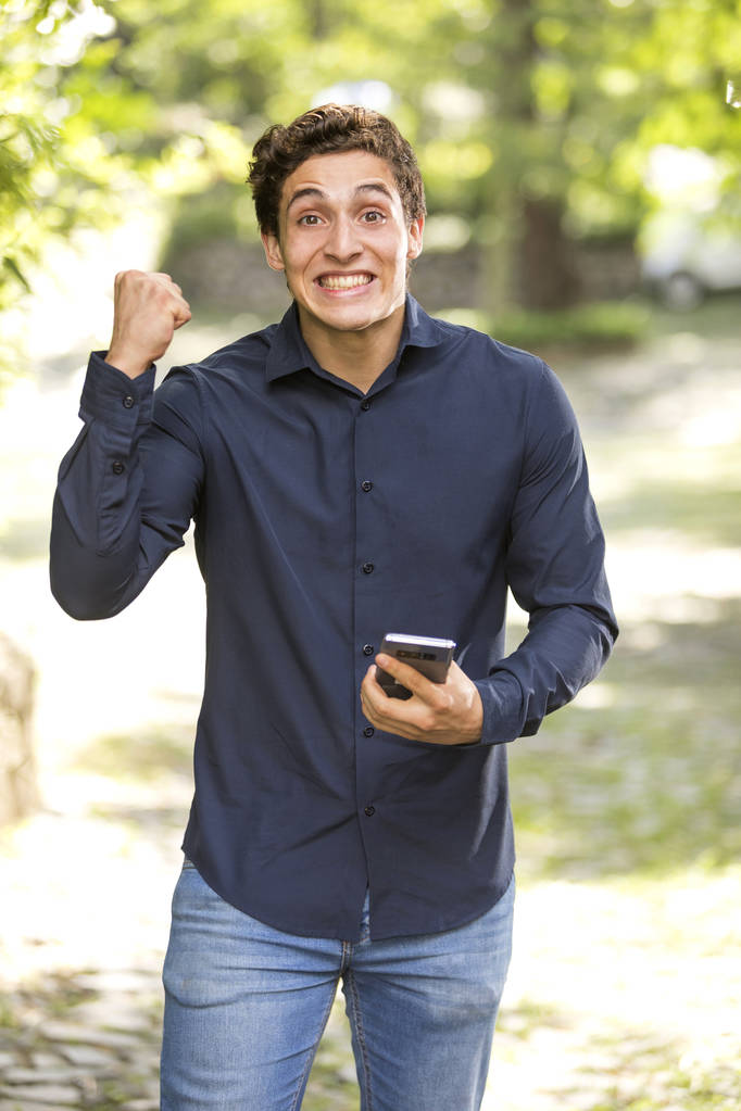Портрет молодого бізнесмена, який посміхається виразом щастя з телефоном
 - Фото, зображення