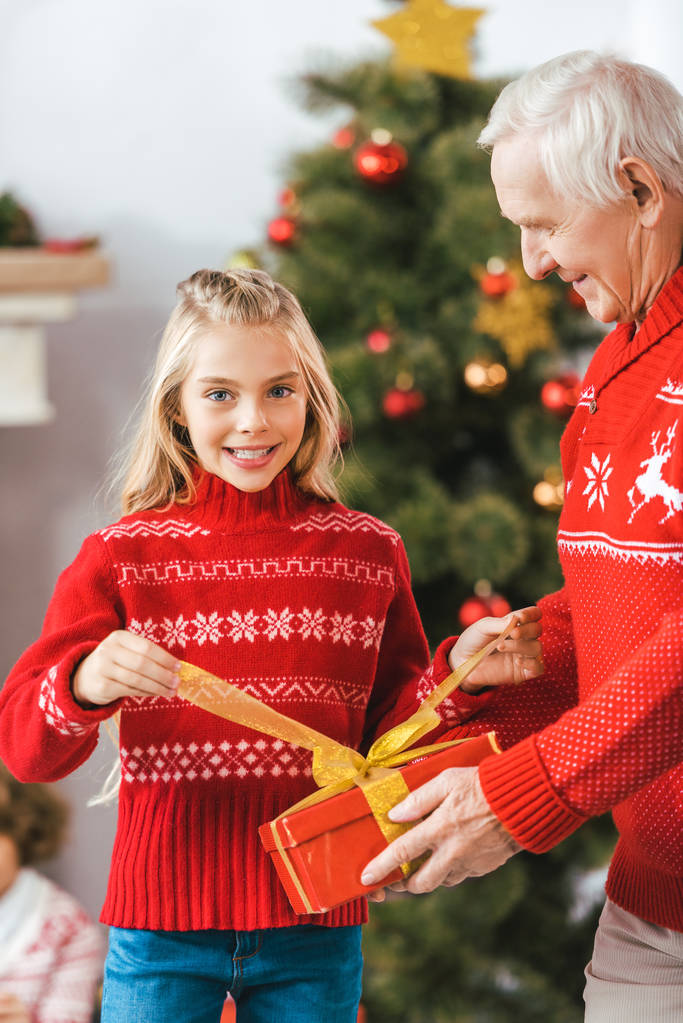 abuelo y nieta desempacar regalos de Navidad juntos
 - Foto, Imagen