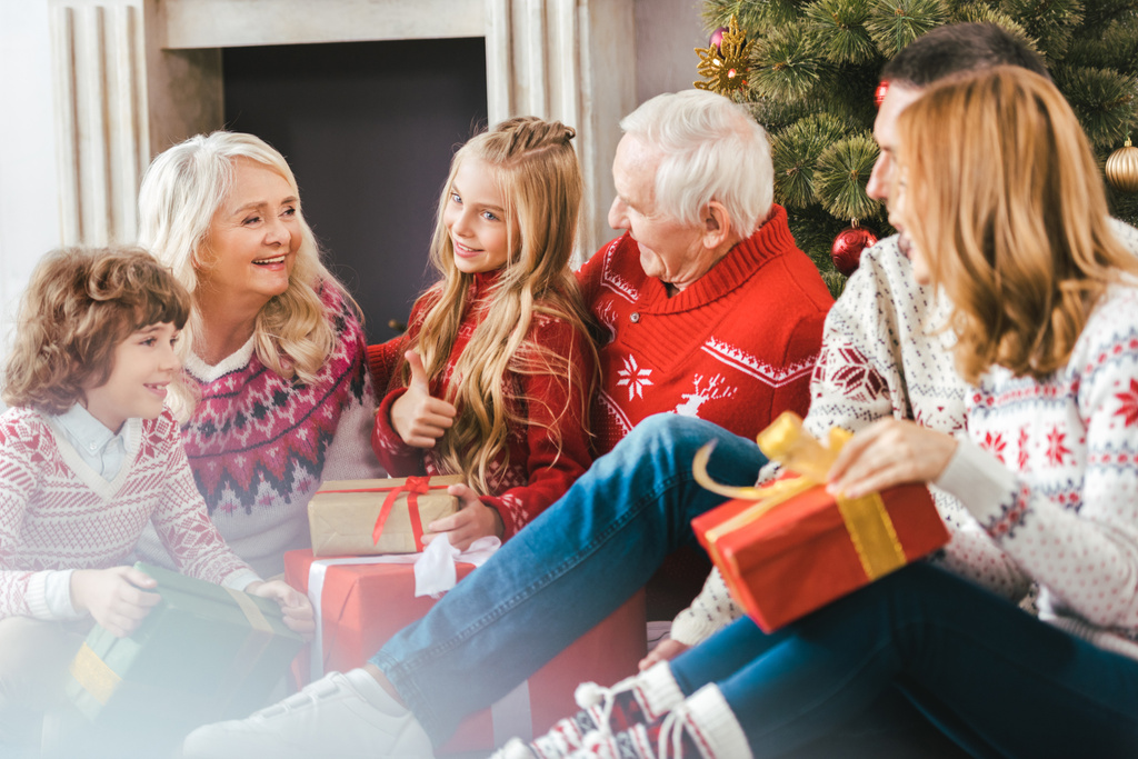 Szczęśliwa rodzina z pudełka, siedząc na podłodze salonu podczas świąt Bożego Narodzenia - Zdjęcie, obraz