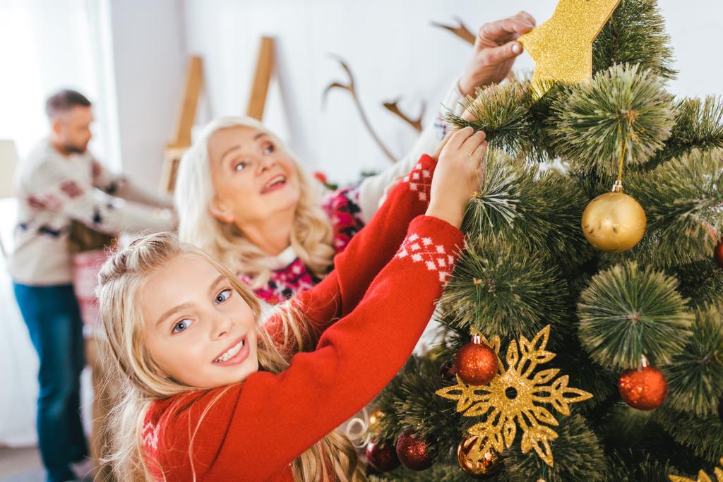 grand-mère et petite-fille décorant ensemble l'arbre de Noël
 - Photo, image