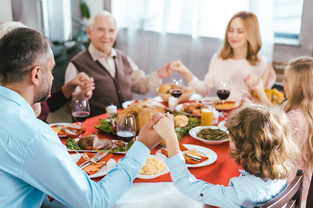 onnellinen perhe rukoilee ennen kiitospäivän illallista kotona
 - Valokuva, kuva