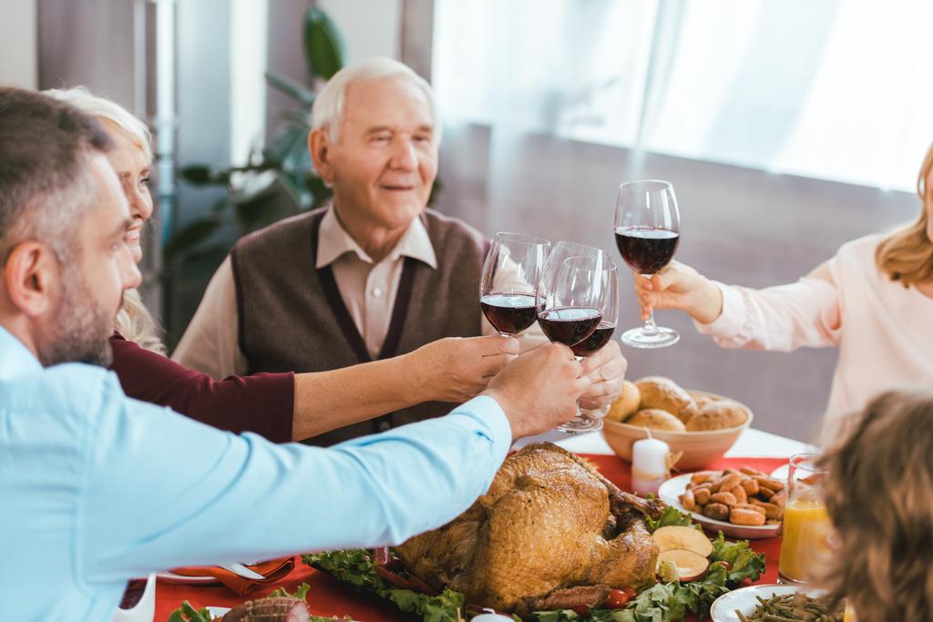 beautiful happy family clinking glasses of wine during thanksgiving dinner - Photo, Image