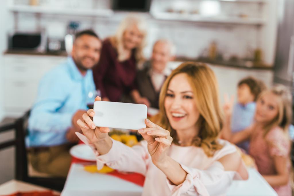 jovem feliz tomando selfie com sua família durante o jantar de ação de graças
 - Foto, Imagem
