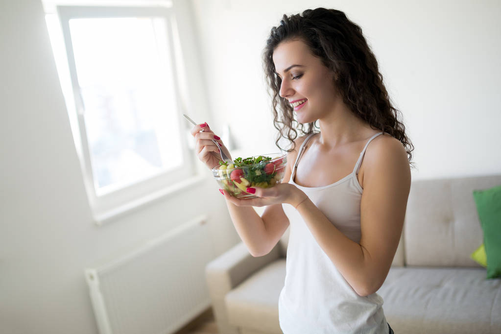 Фитнес молодая женщина ест здоровую пищу после тренировки
 - Фото, изображение