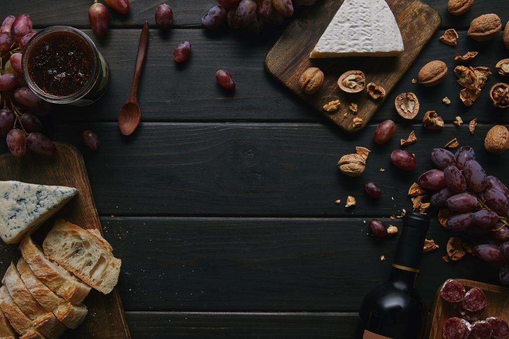 木製のテーブルにワインのボトルと様々 なおいしい軽食のトップ ビュー - 写真・画像