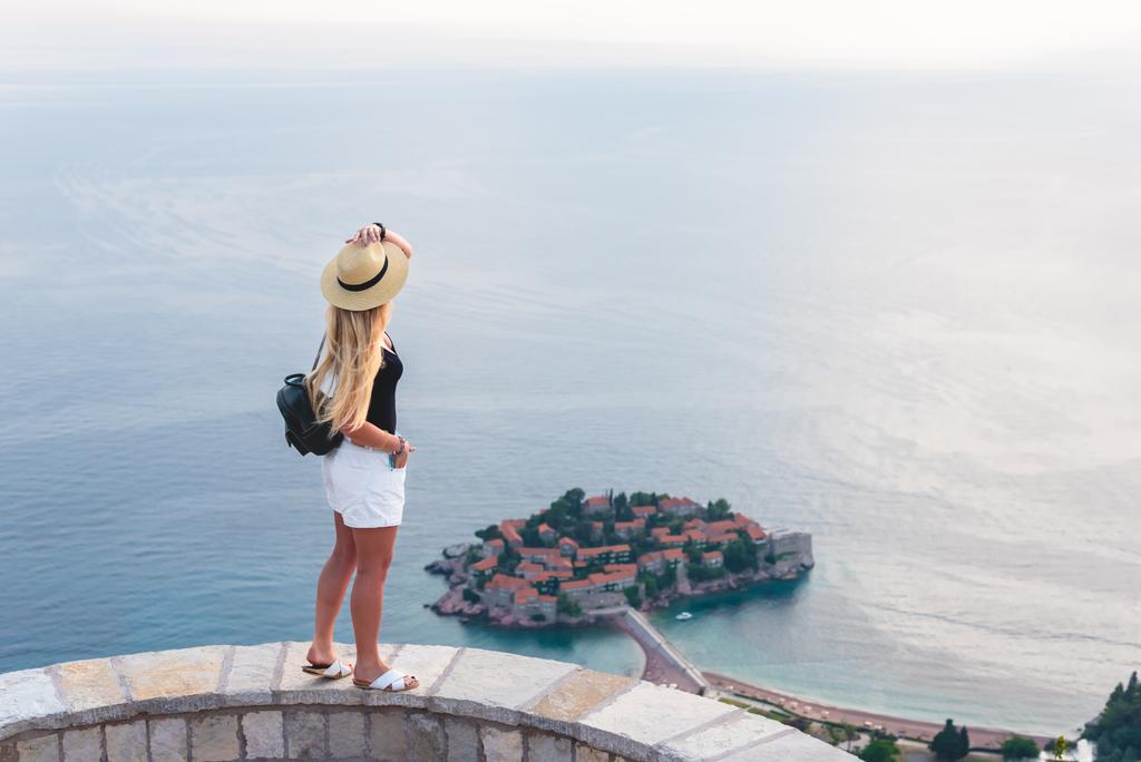 mujer de pie y mirando la isla de San Esteban en el mar Adriático, Budva, Montenegro
  - Foto, imagen