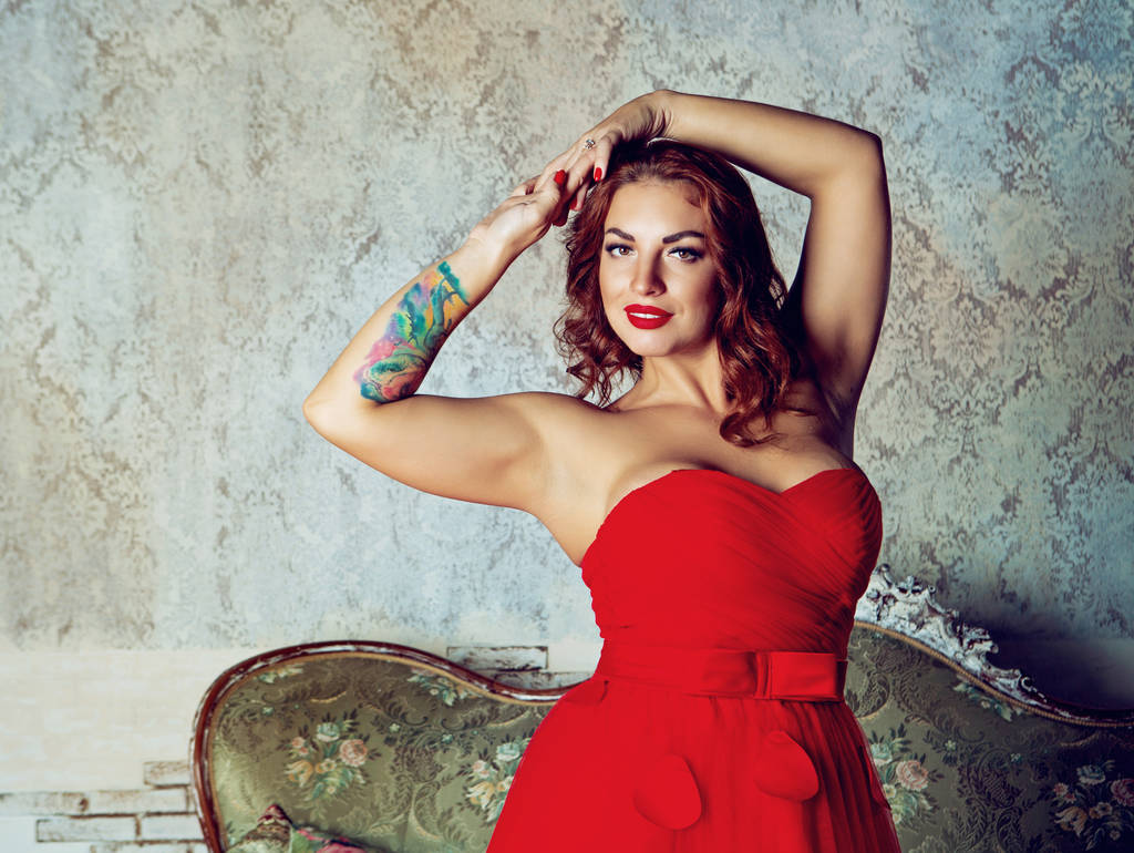 hermosa mujer joven con rosa tatoo, con un vestido rojo
 - Foto, Imagen