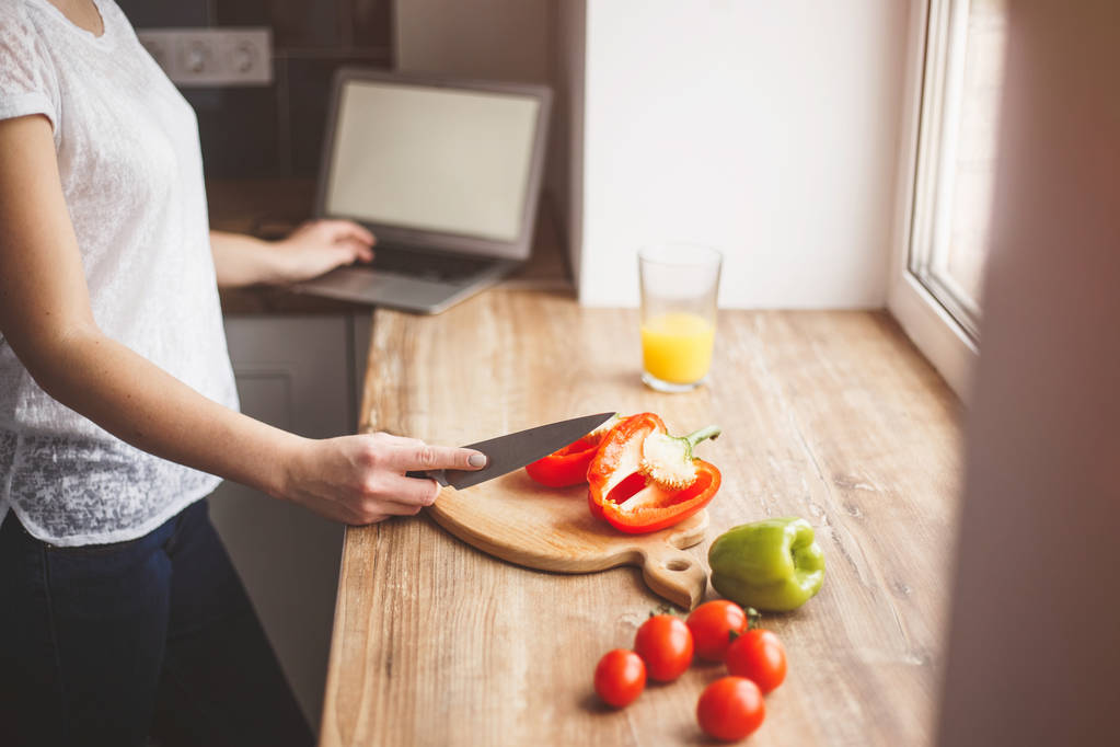 Egy nő készül az étkezés és dolgozik a laptop. A közelben van egy - Fotó, kép