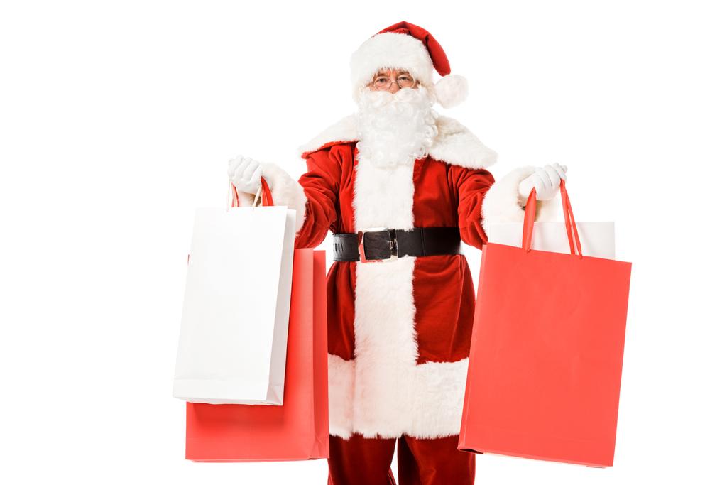 Santa claus stojący z torby papierowe w ręce i patrząc na kamery na białym tle - Zdjęcie, obraz