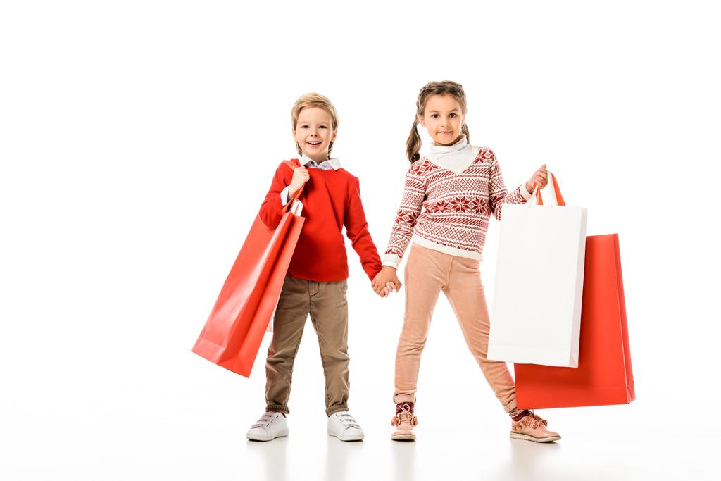 Imádnivaló kis gyerekek a gazdaság nagy papír táskák elszigetelt fehér karácsony-pulóver - Fotó, kép
