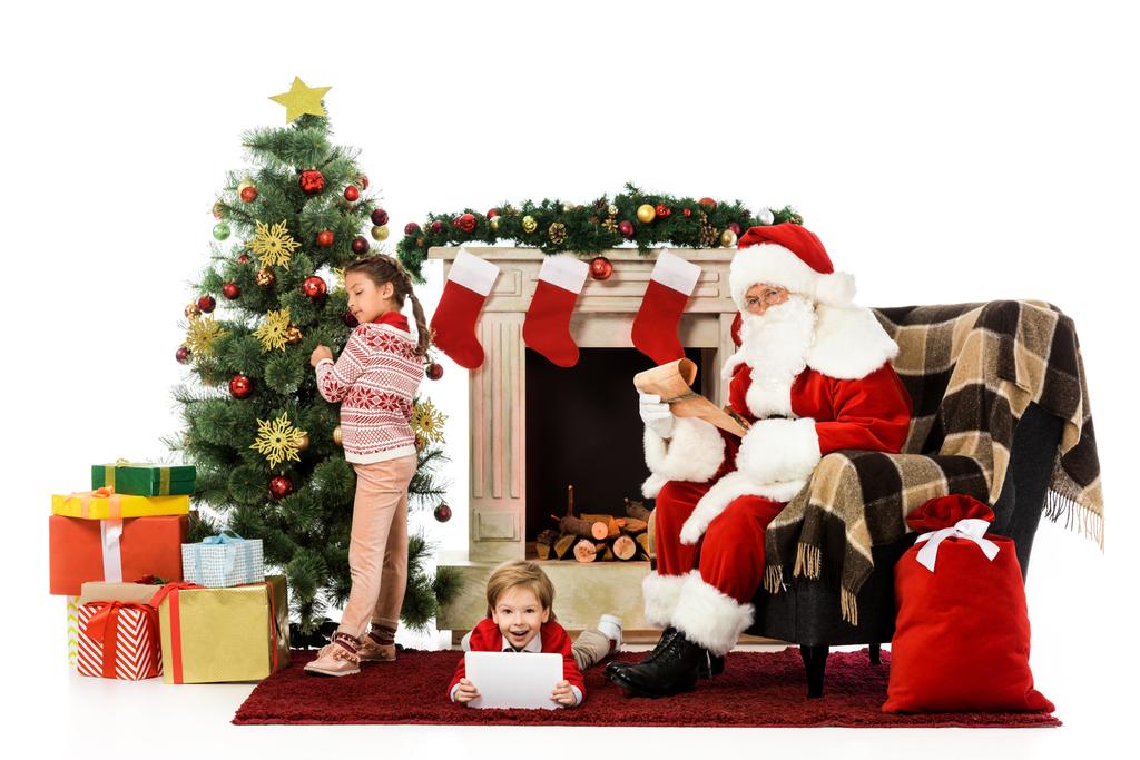 щасливі діти і Санта дивиться на камеру, проводячи час разом ізольовано на білому
 - Фото, зображення