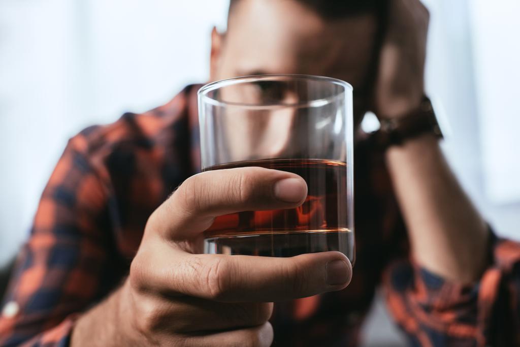 lähikuva masentunut mies pitämällä lasi viskiä
 - Valokuva, kuva